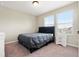 Bedroom featuring a bed with a gray comforter, a nightstand, and a window that provides natural light at 4917 Eagle Rock Dr, Wimauma, FL 33598
