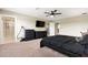 Spacious bedroom features a large bed, dark furniture, walk-in shower access, and a ceiling fan for added comfort at 4917 Eagle Rock Dr, Wimauma, FL 33598