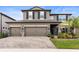 Charming two-story home with a three-car garage, paver driveway, and neatly landscaped front yard at 4917 Eagle Rock Dr, Wimauma, FL 33598