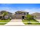 Inviting two-story home with a well-manicured lawn, paver driveway, and a two-car garage at 4917 Eagle Rock Dr, Wimauma, FL 33598