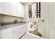 A charming pantry featuring a custom wall sculpture, decorative wine racks, and white cabinets topped with granite countertops at 4917 Eagle Rock Dr, Wimauma, FL 33598