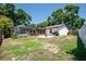 Backyard featuring a screened-in pool, patio area, grill, and mature trees, creating a private outdoor space at 502 Timber Bay E Cir, Oldsmar, FL 34677