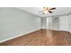 Spacious bedroom with wood-look floors, ceiling fan, and access to additional rooms at 502 Timber Bay E Cir, Oldsmar, FL 34677