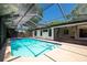 Screened-in pool area with a pool, surrounded by lush greenery and a backyard view at 502 Timber Bay E Cir, Oldsmar, FL 34677