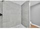 Contemporary shower featuring gray tiled walls and a pebble-tiled shower floor at 502 Timber Bay E Cir, Oldsmar, FL 34677