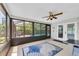 Enclosed sunroom with tile floors and a view of the pool, featuring a ceiling fan and plenty of natural light at 502 Timber Bay E Cir, Oldsmar, FL 34677