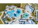Aerial view of community pool area, featuring multiple pools, ample lounge chairs, and shaded cabanas at 5090 Caravel Pt, Land O Lakes, FL 34638