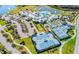 Aerial view of community amenities featuring a large pool, tennis courts, clubhouse, and ample parking at 5090 Caravel Pt, Land O Lakes, FL 34638