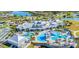 Aerial view of community clubhouse with pools, tennis courts, and landscaping, next to a peaceful lake at 5090 Caravel Pt, Land O Lakes, FL 34638