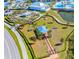 Aerial view of community dog park and adjacent recreational area with a lake in the background at 5090 Caravel Pt, Land O Lakes, FL 34638