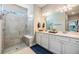 Bright bathroom featuring a glass enclosed shower with seat, a double sink, and white cabinets at 5090 Caravel Pt, Land O Lakes, FL 34638