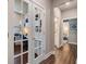 Hallway view with French doors leading to a bright office space with built-in shelving and work area at 5090 Caravel Pt, Land O Lakes, FL 34638