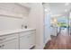Bright laundry room featuring a sink, storage cabinets, and modern fixtures at 5090 Caravel Pt, Land O Lakes, FL 34638