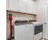 Functional laundry area features modern washer, dryer, and built-in cabinets for efficient storage and organization at 5090 Caravel Pt, Land O Lakes, FL 34638