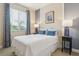 Cozy bedroom is brightly lit and features a decorative window, a bed and matching lamps at 542 Harbor Ridge Dr, Palm Harbor, FL 34683