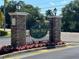 Harbor Ridge Townhomes entrance sign with manicured landscaping and flowers at 542 Harbor Ridge Dr, Palm Harbor, FL 34683
