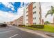 View of the condominium building, showcasing its architectural design with a parking area and landscaped grounds at 5501 80Th N St # 207, St Petersburg, FL 33709