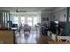Well-lit living room with large windows, hardwood floors, a ceiling fan, and coastal decor at 5501 80Th N St # 207, St Petersburg, FL 33709