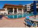 Community pool area with seating, blue lounge chairs and shade, for outdoor relaxation at 5501 80Th N St # 207, St Petersburg, FL 33709