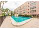 Community pool with multi-story residential building, landscaping, and outdoor seating areas at 5501 80Th N St # 207, St Petersburg, FL 33709