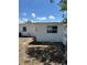 View of the home's white exterior, back yard, window and blue sky with puffy white clouds at 5608 Larimer Dr, Tampa, FL 33615