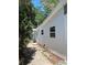 Side view of the home featuring fresh white paint, windows, and tidy landscaping at 5608 Larimer Dr, Tampa, FL 33615