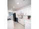 Modern kitchen featuring white cabinets, quartz countertops, black hardware, and stainless steel appliances at 5608 Larimer Dr, Tampa, FL 33615