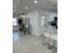 A well-lit living room with tiled floors and modern decor leads to a kitchen with a breakfast bar at 5608 Larimer Dr, Tampa, FL 33615