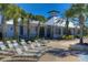 Bright and airy clubhouse with lots of light, lounge chairs, and palm trees under a clear blue sky at 5865 Meadowpark Pl, Lithia, FL 33547