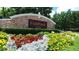 Entrance to FishHawk Ranch lined with red, yellow, and white blooming flowers with stone sign at 5865 Meadowpark Pl, Lithia, FL 33547