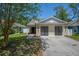 Attractive home with light yellow siding, black garage doors, and a sidewalk at 5865 Meadowpark Pl, Lithia, FL 33547