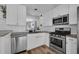 Well-lit modern kitchen featuring white cabinets, stainless steel appliances, and subway tile backsplash at 5865 Meadowpark Pl, Lithia, FL 33547