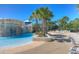 Resort-style pool with a rock waterfall feature, palm trees, and lounge chairs under a clear blue sky at 5865 Meadowpark Pl, Lithia, FL 33547