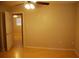 Bedroom with neutral walls, laminate floors and a ceiling fan, with an open door to an adjacent room at 6326 55Th N Ave, St Petersburg, FL 33709
