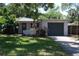 Charming one-story home with a well-maintained lawn, lush landscaping, and an attached garage at 6326 55Th N Ave, St Petersburg, FL 33709