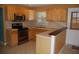 Cozy kitchen featuring wooden cabinets, stainless steel appliances, and an eat-in breakfast bar at 6326 55Th N Ave, St Petersburg, FL 33709