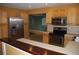A kitchen boasts stainless steel appliances, wooden cabinetry, and a bar overlooking an open living space at 6326 55Th N Ave, St Petersburg, FL 33709