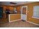 An airy kitchen and dining area, illuminated by natural light, features wooden cabinets and a serving bar at 6326 55Th N Ave, St Petersburg, FL 33709