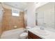 Bathroom featuring tiled walls, a tub and shower combo, a vanity, and a window at 6547 Castle Green Pl, Zephyrhills, FL 33541