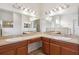 Bathroom showcasing dual sinks, vanity with storage, and large mirrors with overhead lights at 6547 Castle Green Pl, Zephyrhills, FL 33541