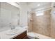 Bathroom featuring a walk-in shower with tiled walls, a toilet, and a vanity with sink and storage at 6547 Castle Green Pl, Zephyrhills, FL 33541