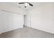 Bright bedroom with a ceiling fan, carpet flooring, closet, and a door leading to another room at 6547 Castle Green Pl, Zephyrhills, FL 33541