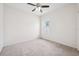 Bright bedroom with a ceiling fan, a window with a view of the yard, and carpet flooring at 6547 Castle Green Pl, Zephyrhills, FL 33541