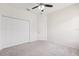 Bright bedroom with a ceiling fan, carpet flooring, closet, and a door leading to another room at 6547 Castle Green Pl, Zephyrhills, FL 33541