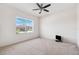 Carpeted bedroom featuring a ceiling fan and a bright window with neighborhood views at 6547 Castle Green Pl, Zephyrhills, FL 33541