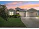 Inviting one-story home featuring a three-car garage, well-maintained lawn, and attractive curb appeal at 6547 Castle Green Pl, Zephyrhills, FL 33541