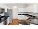 Modern kitchen featuring stainless steel appliances, granite countertops, and bright white cabinetry at 6547 Castle Green Pl, Zephyrhills, FL 33541