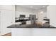 Modern kitchen featuring stainless steel appliances, granite countertops, and bright white cabinetry at 6547 Castle Green Pl, Zephyrhills, FL 33541