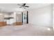 Open concept living room with neutral carpet, wood floors, ceiling fan, and easy access to the kitchen and backyard at 6547 Castle Green Pl, Zephyrhills, FL 33541