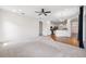 Open concept living room with neutral carpet, wood floors, ceiling fan, and easy access to the kitchen at 6547 Castle Green Pl, Zephyrhills, FL 33541